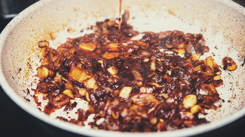 pan with onions being deglazed