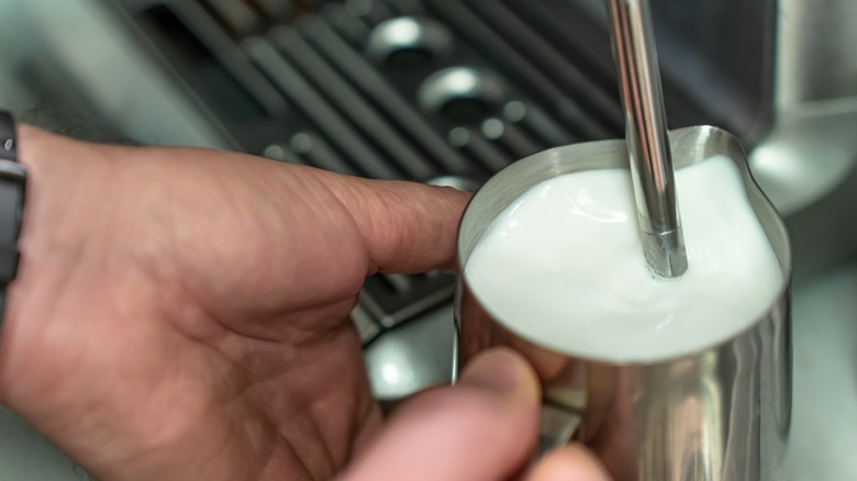 steam wand in milk jug