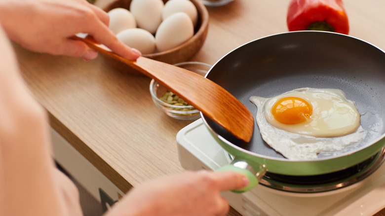 Person frying an egg