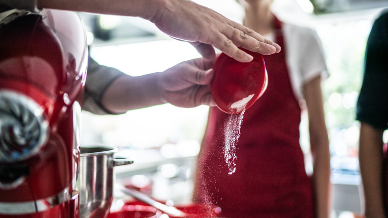 pouring ingredients into mixing bowl