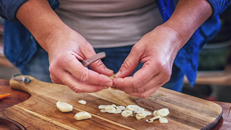 Person cutting garlic cloves