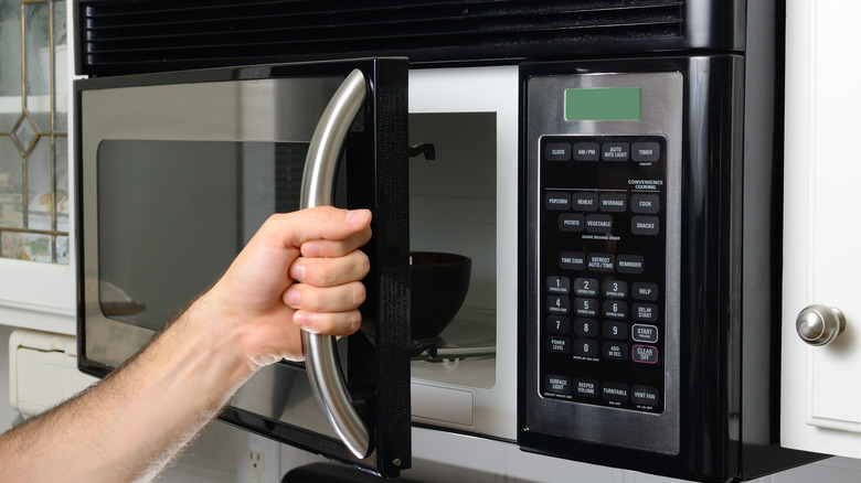 Person opening microwave door