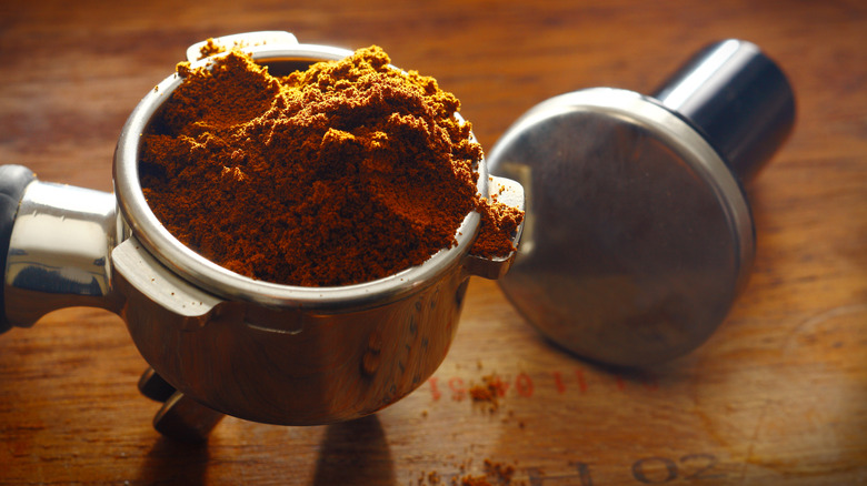 a portafilter overflowing with coffee grounds