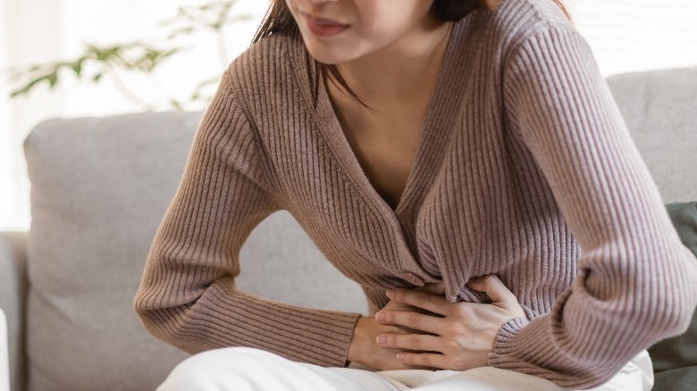 Woman with stomach problem holding her stomach