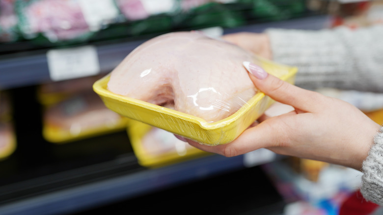 woman holding package of chicken