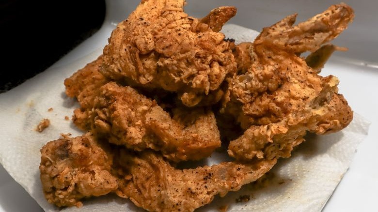 Fried chicken draining on paper towels