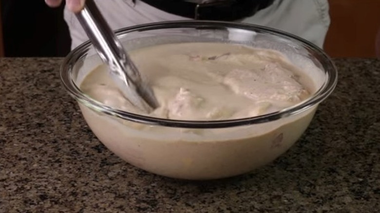 Chicken pieces in bowl of buttermilk