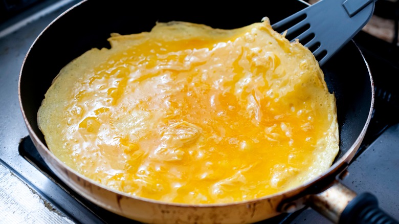 spatula lifting omelet in pan