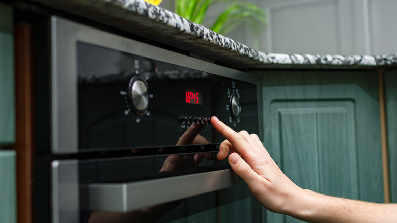 Person touching oven controls