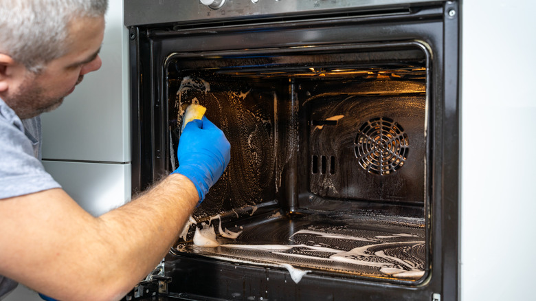 Person cleaning oven interior