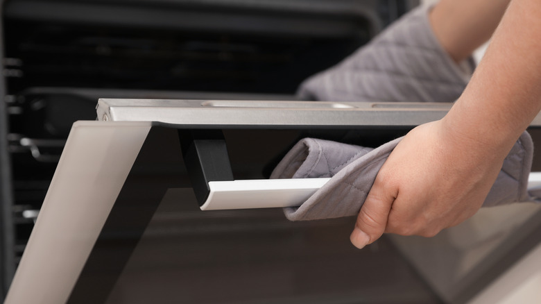 Person holding oven door open