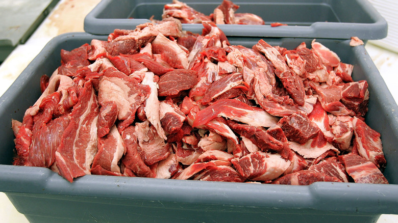 Large plastic box full of raw beef slices