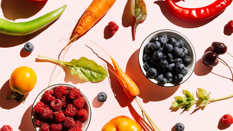 Flat lay of fruits and vegetables on pink background