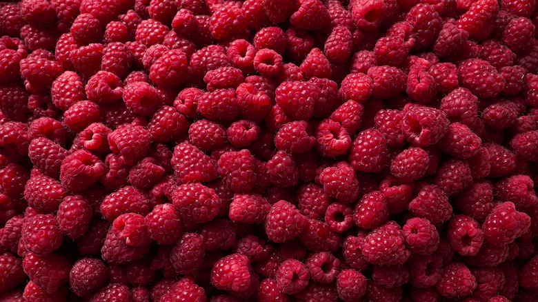 A pile of red raspberries