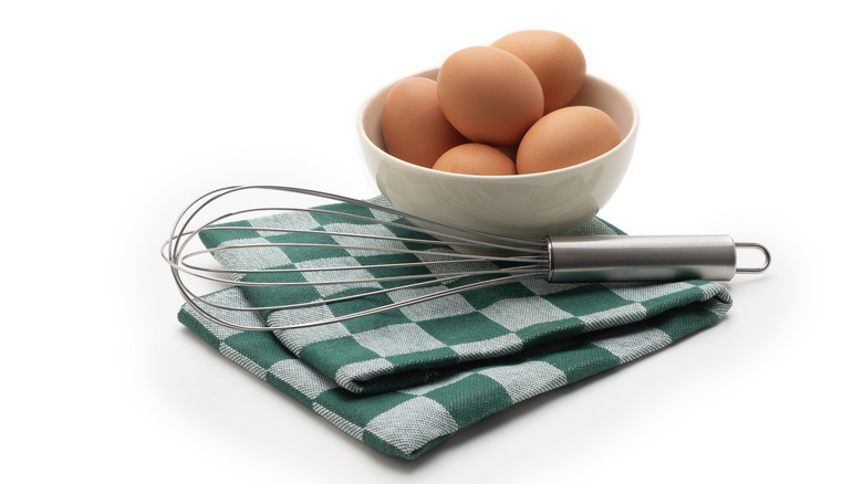 Eggs and whisk with linen