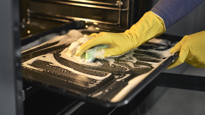 person cleaning oven