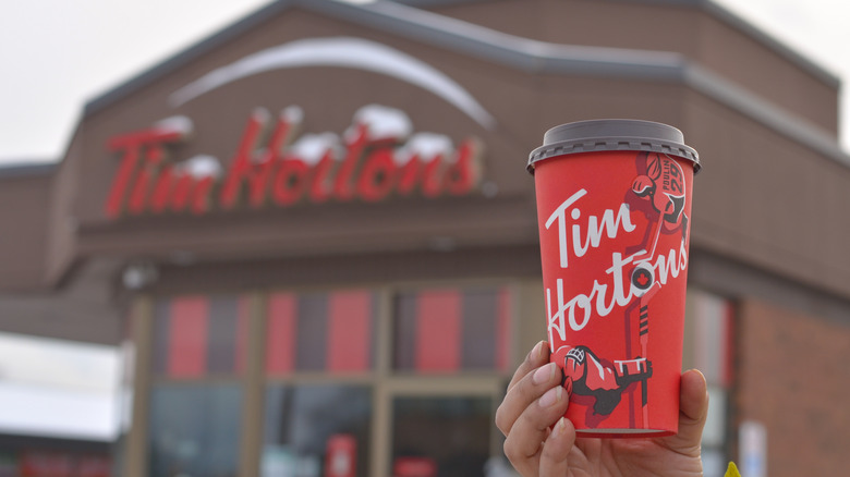 Tim Hortons cup with storefront in background