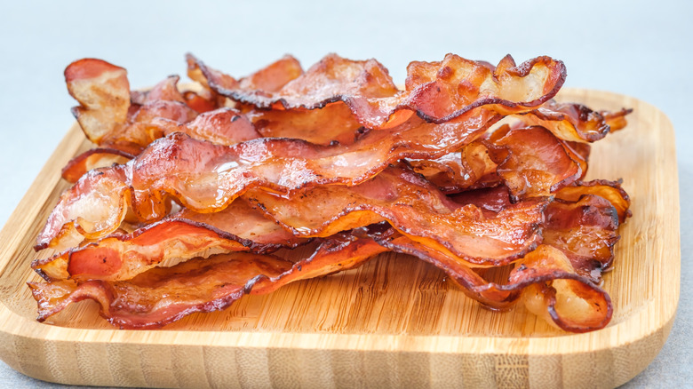 Cooked bacon on wooden board