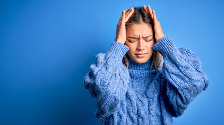 woman holding forehead in pain