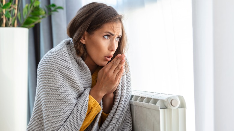 woman feeling cold by heater