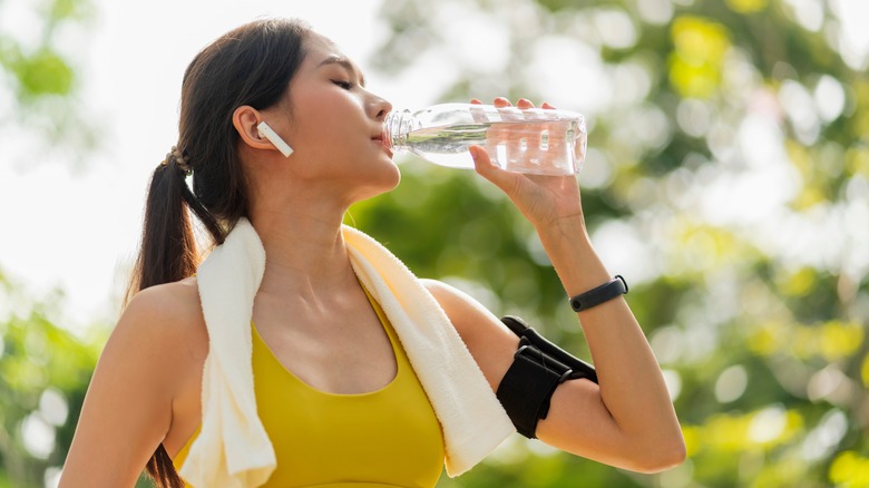 woman drinking water during exercise