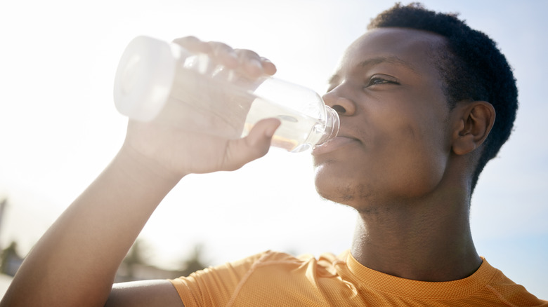 man drinking water during workout