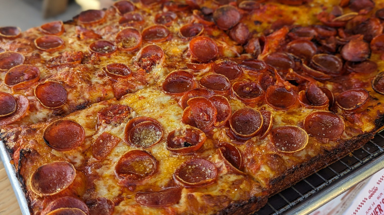 Square pizza slices covered in cupped pepperoni