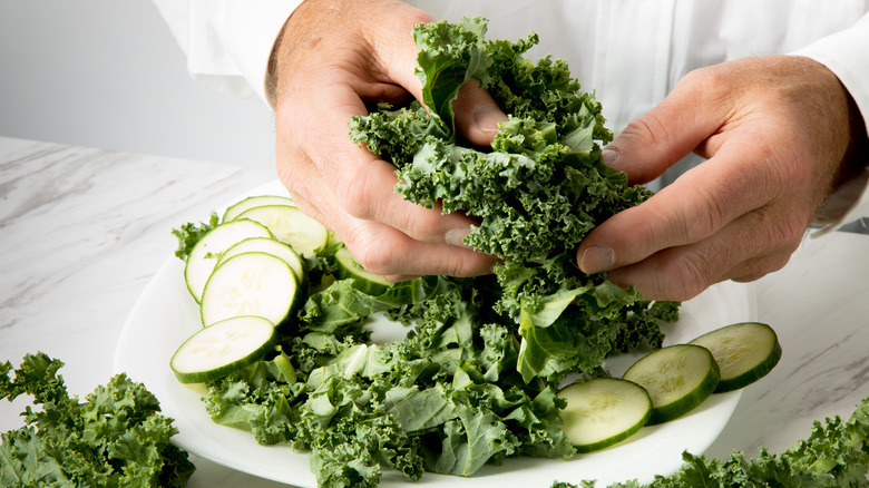 person massaging salad