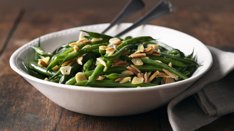 green beans with sautéed garlic and slivered almonds in white bowl