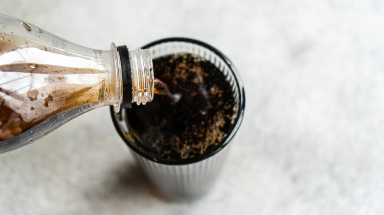 Bottle of soda being poured into glass