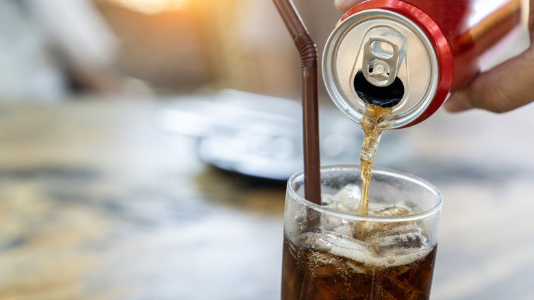 Coca-Cola being poured into glass from can