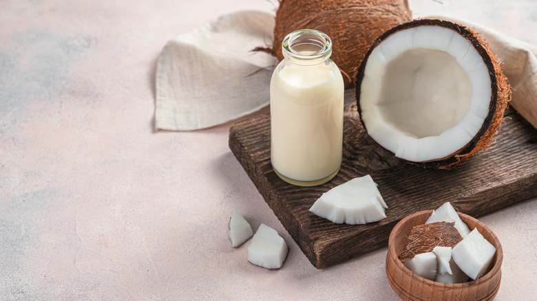 glass bottle of coconut milk with coconuts