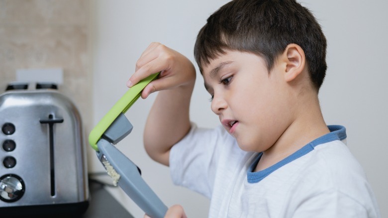 Young boy using garlic press