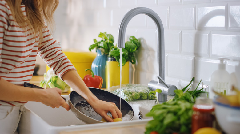 washing frying pan in sink