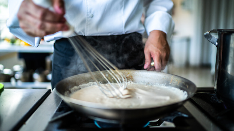 Person making white sauce