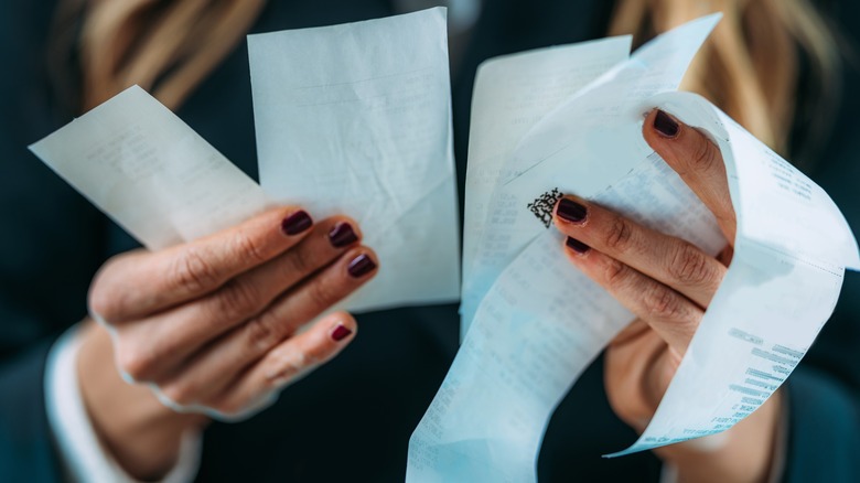 Person holding several receipts