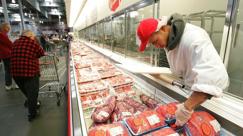 worker arranging meat 