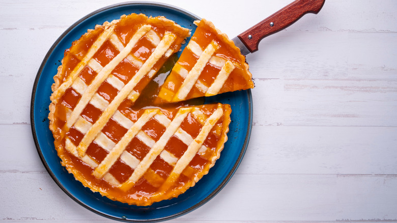 Peach crostata cut with knife