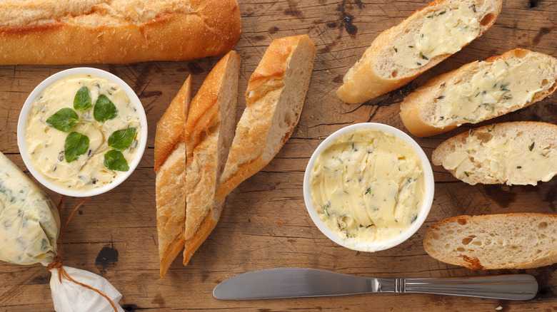 Baguette with bowls of flavored butter