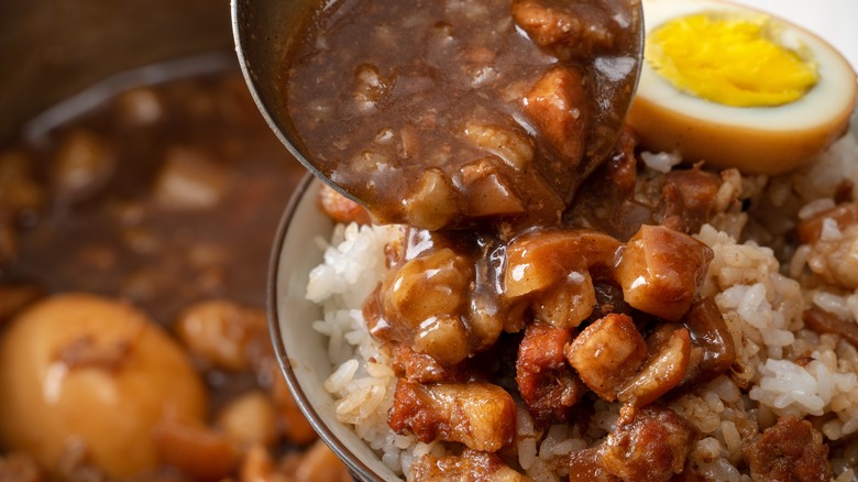 Ladle of stew over rice