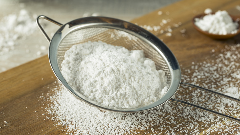 confectioners' sugar being sieved 
