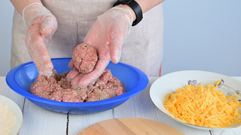 Person shaping raw sausage meat