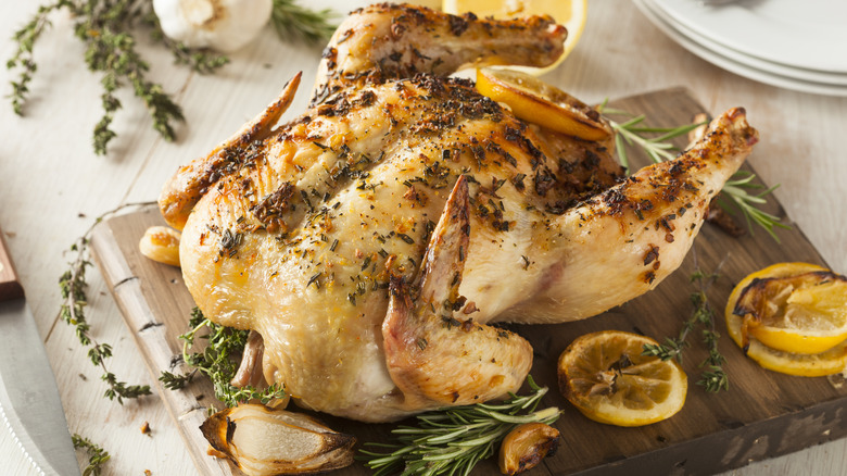 chicken with herbs on wooden board