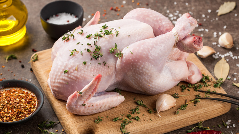 whole raw chicken on cutting board