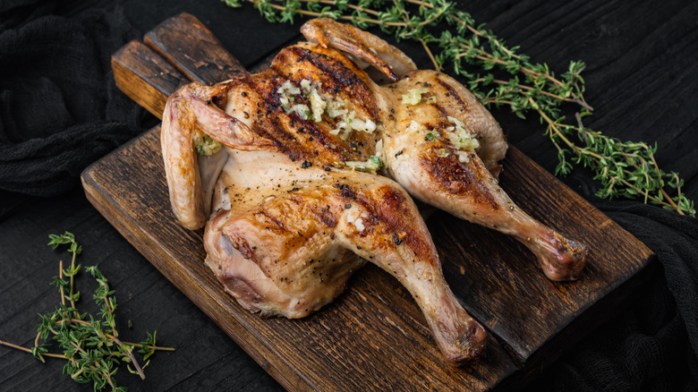 spatchcocked chicken on wooden board