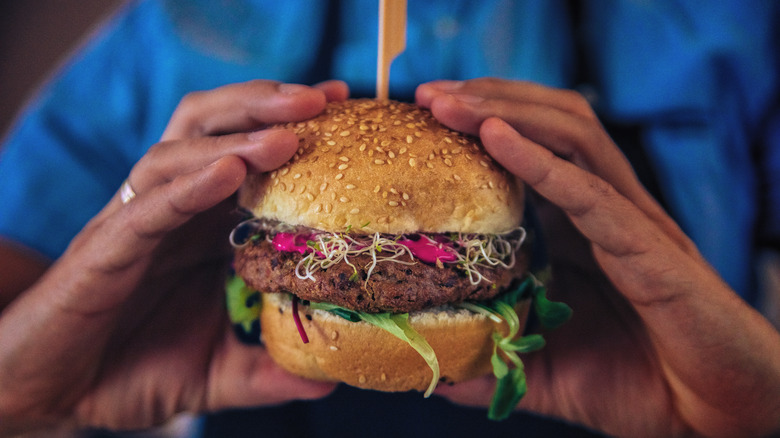 man holding a veggie burger