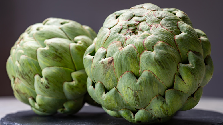 two artichokes on slate rock