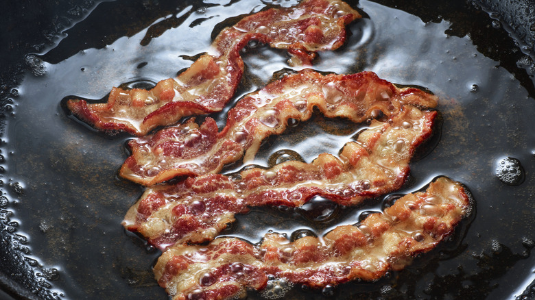 bacon cooking in frying pan