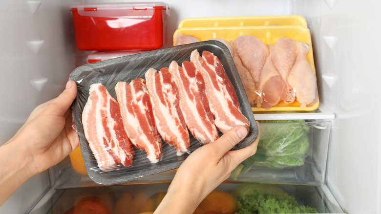 taking raw bacon from refrigerator