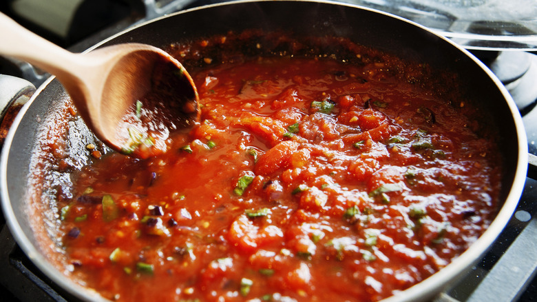 stirring fresh tomato sauce